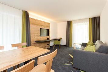 Wohnzimmer der Ferienwohnung mit Couch und Fernseher im Hierlhof nahe dem Großen Alpsee im Allgäu